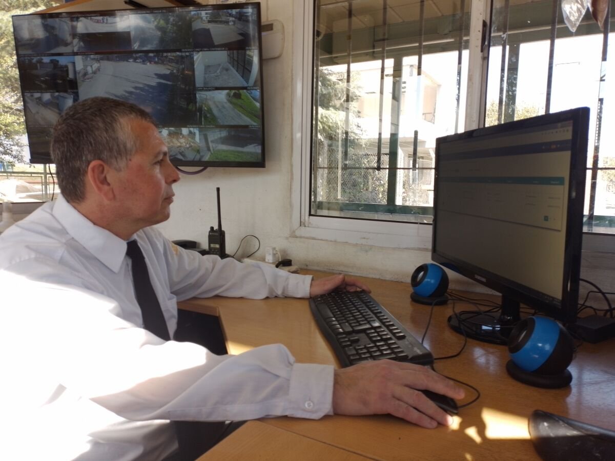 Guardia de seguridad en el centro de monitoreo usando una computadora en su escritorio